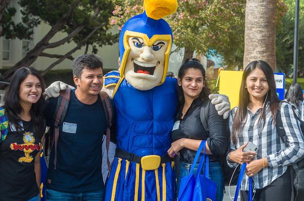 three students with Spartan mascot