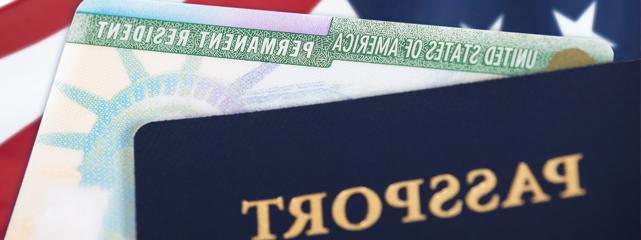 A passport in the foregroud with the American flag in the background.