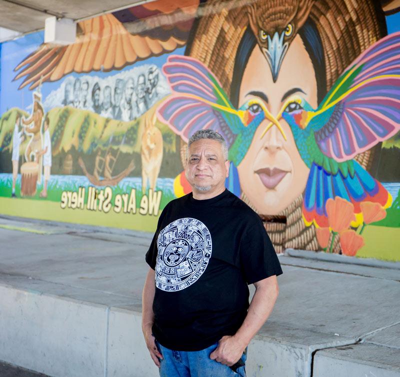 Alfonso Salazar posing in front of his mural.